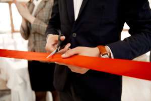 front view cutting red ribbon grand opening building