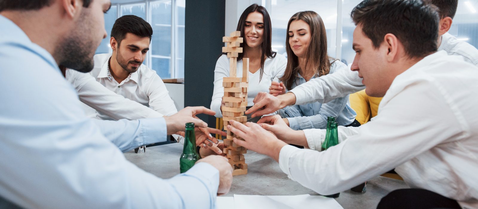 Its almost fall of celebrating successful deal young office workers sitting near the table with alcohol chorcha entertainment